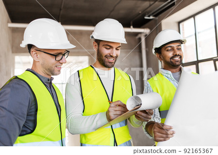 architects in helmets with blueprint at office architects in helmets with blueprint at office 92165367