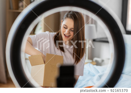 happy girl blogger unpacking parcel box at home happy girl blogger unpacking parcel box at home 92165370