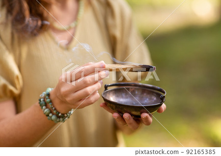 woman with palo santo performing magic ritual 92165385