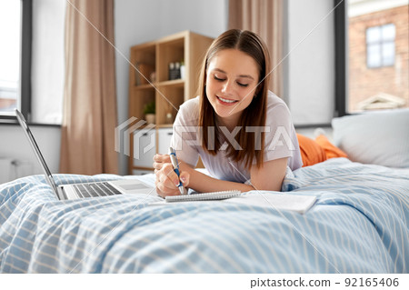 teenage student girl writing to notebook at home 92165406