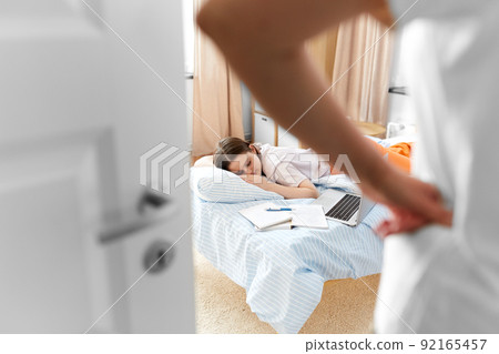 parent looking at student girl sleeping at home 92165457