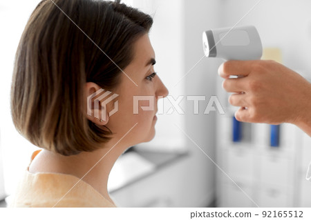 doctor with thermometer and woman at hospital doctor with thermometer and woman at hospital 92165512