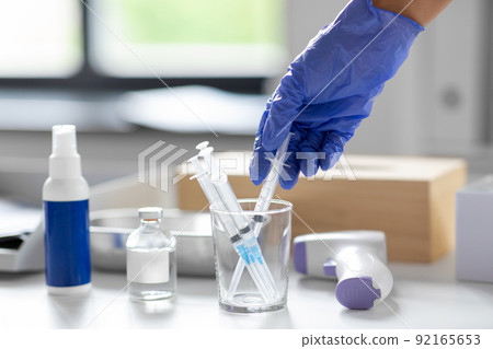 close up of hand in glove taking syringe close up of hand in glove taking syringe 92165653