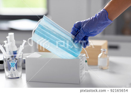 close up of hand in glove taking medical mask close up of hand in glove taking medical mask 92165654
