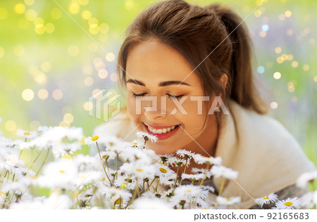 close up of woman smelling chamomile flowers 92165683