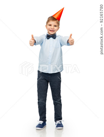boy in birthday party hat showing thumbs up boy in birthday party hat showing thumbs up 92165780