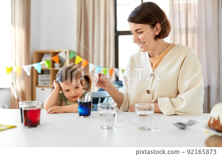 mother with child dyeing easter eggs at home mother with child dyeing easter eggs at home 92165873