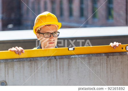 male builder with level measuring wall male builder with level measuring wall 92165892