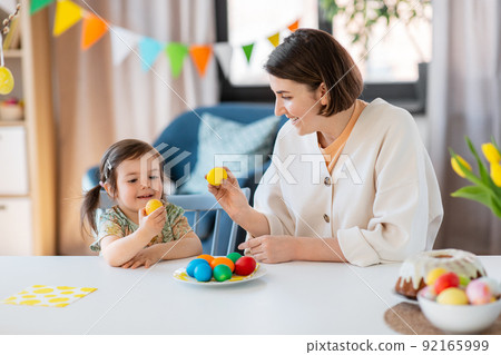 baby girl and mother tapping easter eggs at home baby girl and mother tapping easter eggs at home 92165999