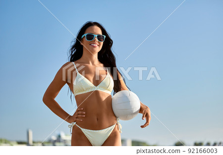 woman in bikini posing with volleyball on beach woman in bikini posing with volleyball on beach 92166003