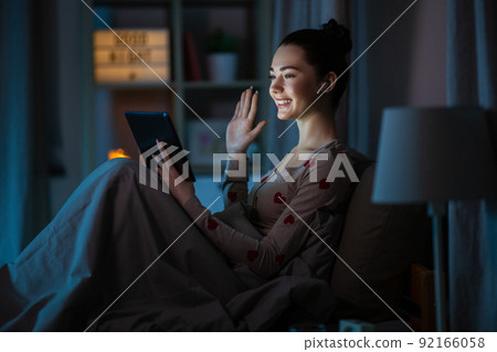 teenage girl having video call on tablet pc in bed teenage girl having video call on tablet pc in bed 92166058