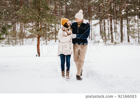 happy smiling couple walking in winter forest happy smiling couple walking in winter forest 92166083