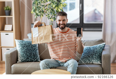 smiling man using smartphone for food delivery smiling man using smartphone for food delivery 92166126