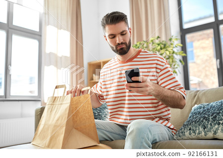 man with phone checking food order at home man with phone checking food order at home 92166131