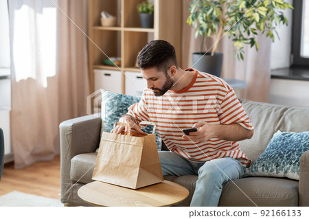 man with phone checking food order at home man with phone checking food order at home 92166133