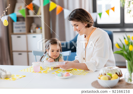 mother with child coloring easter eggs at home mother with child coloring easter eggs at home 92166158