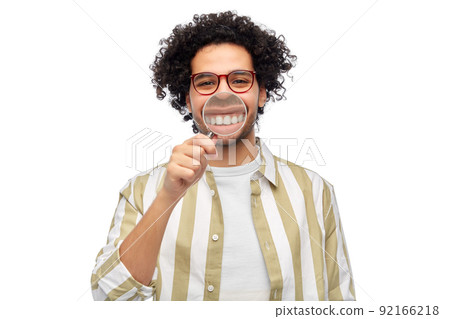 man showing his teeth through magnifying glass man showing his teeth through magnifying glass 92166218