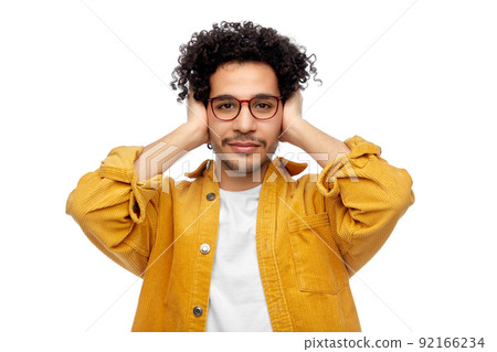 man in yellow jacket closing ears by hands 92166234