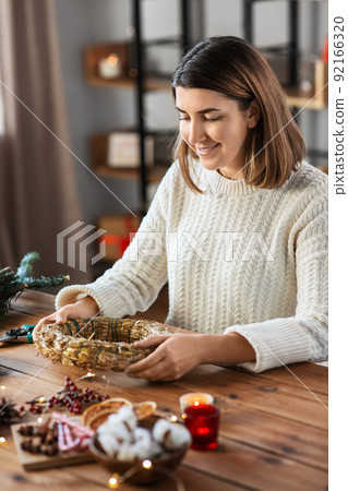 woman making fir christmas wreath at home 92166320