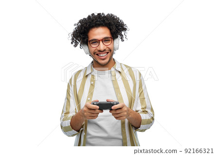 smiling man with gamepad playing video game 92166321