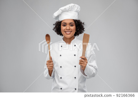 smiling female chef with wooden spoon and spatula smiling female chef with wooden spoon and spatula 92166366