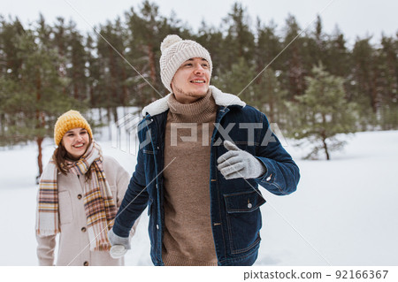 happy smiling couple walking in winter forest happy smiling couple walking in winter forest 92166367
