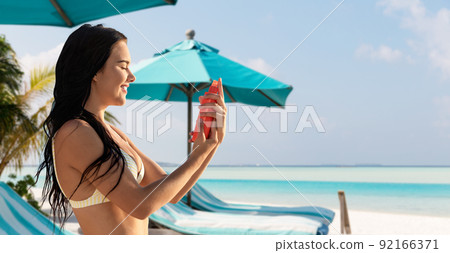 smiling woman in bikini with sunscreen on beach smiling woman in bikini with sunscreen on beach 92166371