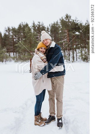 happy smiling couple hugging in winter park 92166372