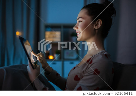 teenage girl with tablet pc in bed at night teenage girl with tablet pc in bed at night 92166411