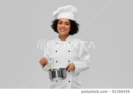 female chef with saucepan and spoon cooking food 92166456