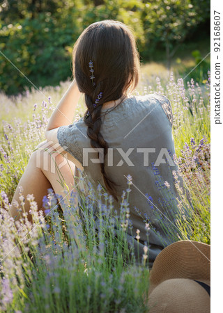 The girl sit in the middle of a lavender field The girl sit in the middle of a lavender field 92168607