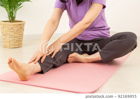Middle woman stretching indoors Middle woman stretching indoors 92169955