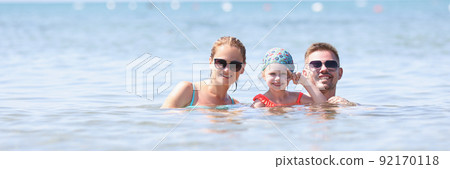 Happy family posing for picture together in sea or ocean Happy family posing for picture together in sea or ocean 92170118