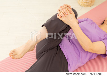 Middle woman stretching indoors Middle woman stretching indoors 92172819