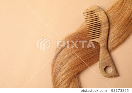 Female hair with hairbrush on beige background Female hair with hairbrush on beige background 92173825