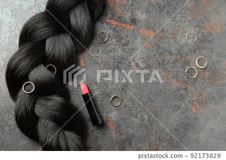 A lock of female hair with rings and lipstick 92173829