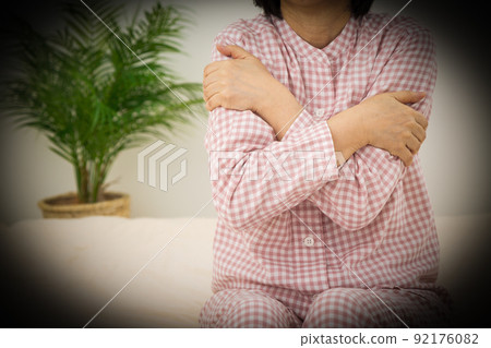 中年婦女穿著睡衣在臥室裡變冷 中年婦女穿著睡衣在臥室裡變冷 92176082