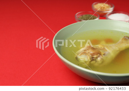 Concept of tasty food with chicken soup on red background Concept of tasty food with chicken soup on red background 92176433