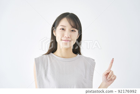 Woman pointing to the right white background 92176992