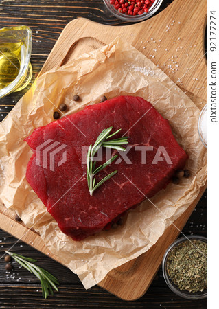 Concept of tasty food with raw beef steak on wooden background 92177274