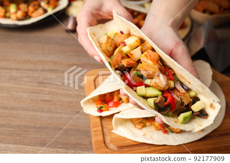 Concept of tasty food with taco on wooden background Concept of tasty food with taco on wooden background 92177909