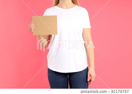 Woman in white t-shirt with space for text on pink background Woman in white t-shirt with space for text on pink background 92178787