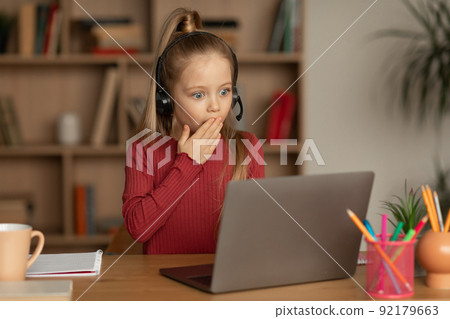Shocked Kid Girl Looking At Laptop Computer Learning Online Indoors 92179663