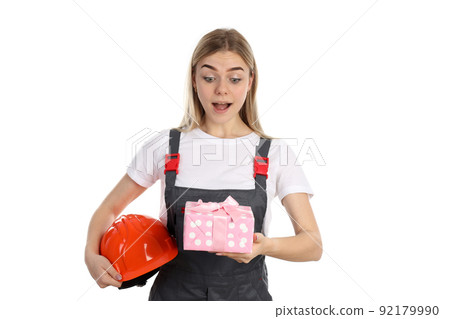 Builder girl with gift box isolated on white background Builder girl with gift box isolated on white background 92179990