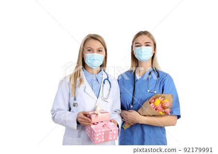 Female doctor and nurse with gifts isolated on white background 92179991