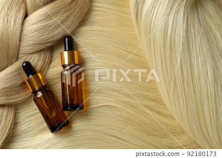 Concept of hair care with bottles of cosmetic and female hair Concept of hair care with bottles of cosmetic and female hair 92180173