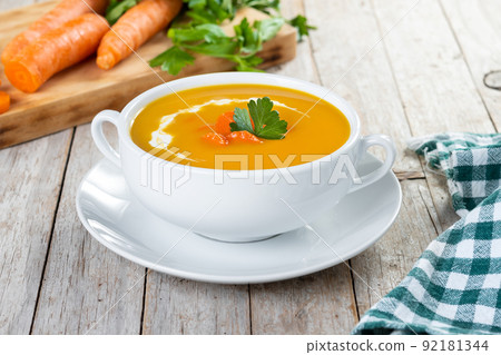 Carrot soup with cream and parsley Carrot soup with cream and parsley 92181344