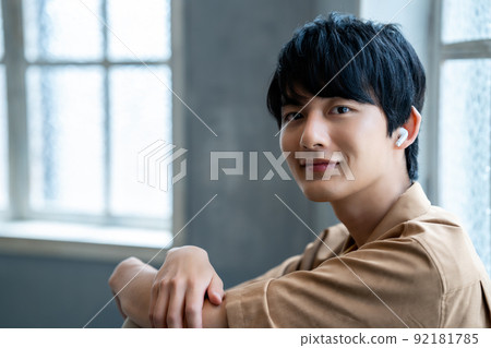 Young man listening to music in the room Young man listening to music in the room 92181785