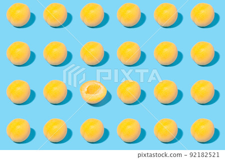 Summer pattern of ripe apricots on a blue background - fruit harvest concept Summer pattern of ripe apricots on a blue background - fruit harvest concept 92182521