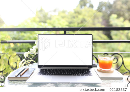 Laptop white screen on glass table with berry juice 92182887